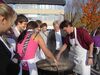 Kaufmann vor großen Grillpfanne bei Vorbereitung der Hauptspeise durch Schüler des Gymnasiums Durmersheim